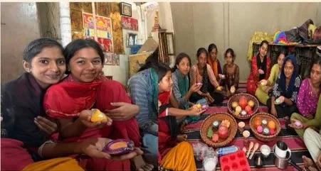 Women artisans holding the terracotta candles they made