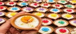 A tray of terracotta diya candles with flower designs