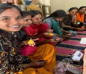 A trainee smiles while finishing a candle with her group